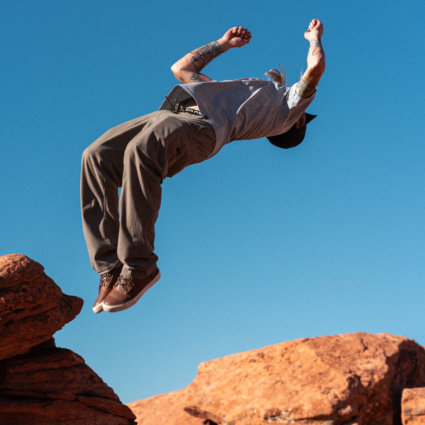 Pro Skater David Gravette in Ridgemont Outback boot preforming backflip in St. George, Utah. Shows active and adventure-ready footwear. Outbacks have full grain leather, cream (off-white) foxing, brown laces, lace hooks, green colored waxed cotton canvas, real rubber gum colored lugged tread. Outdoor boot, outdoor boots, outdoor shoe, outdoor shoes, Ridgemont x David Gravette, St. Geroge, Utah, Ridgemont x backflips, outside.