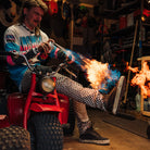 Nomad David Dobrinski (aka Doctor David) in Ridgemont Outback boot in colors Black Grey sitting on ATC blowing fire on Outback boots. Outdoor shoes, outdoor boot.